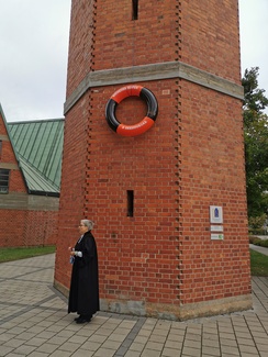 Pfarrerin Wittmann-Schlechtweg mit Kirchturm und Rettungsring