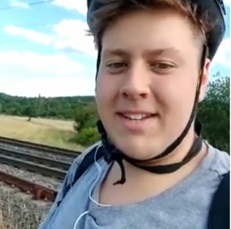 Jugendlicher mit Helm vor Schienen